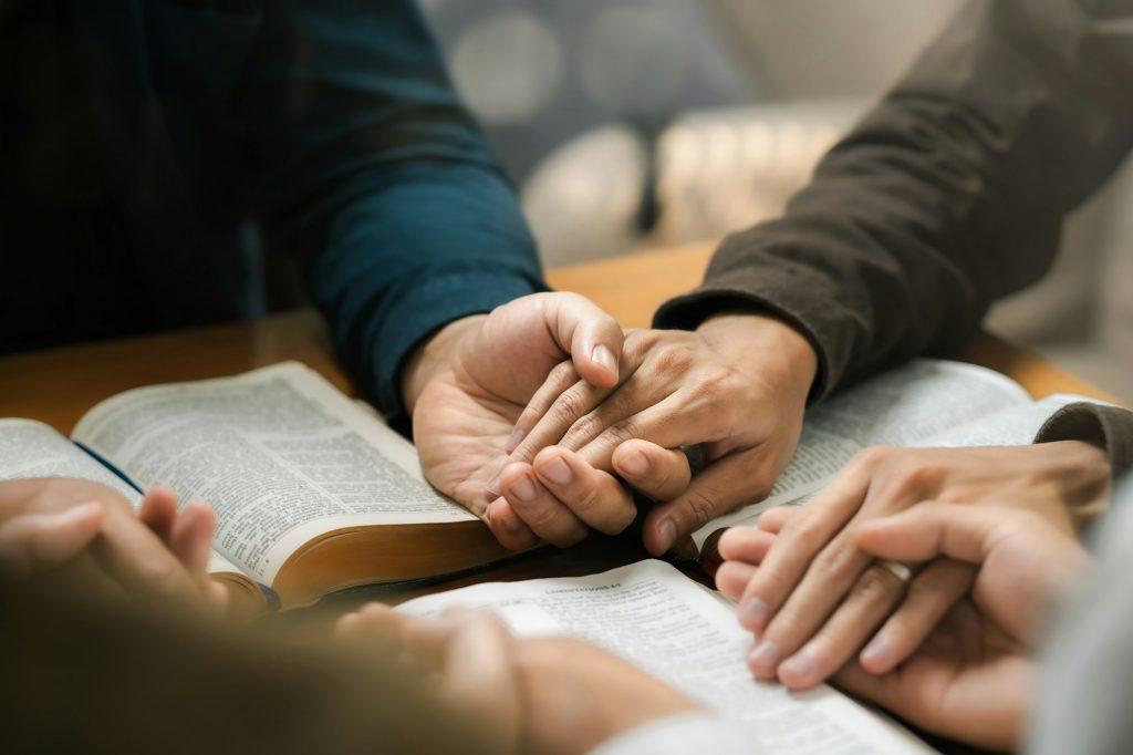 Group of young Christians praying, holding hands and praying together The concept of praying to God